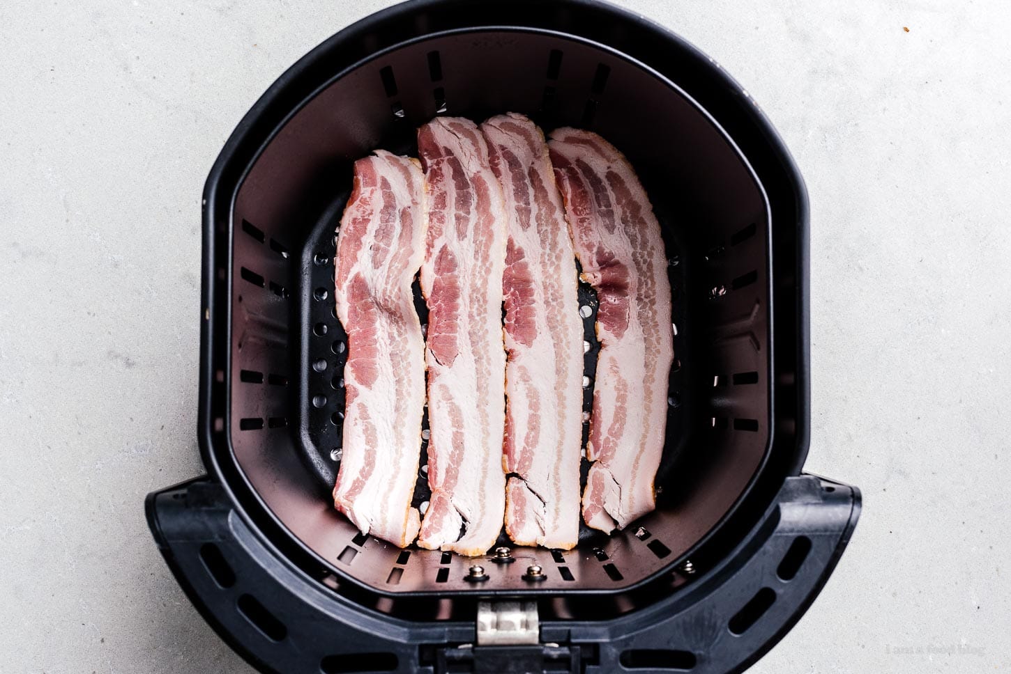 bacon in an air fryer basket | sharefavoritefood.com