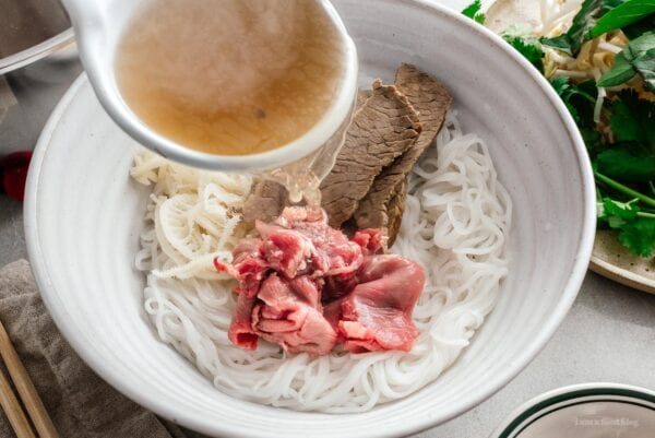 ladling pho soup over steak | sharefavoritefood.com